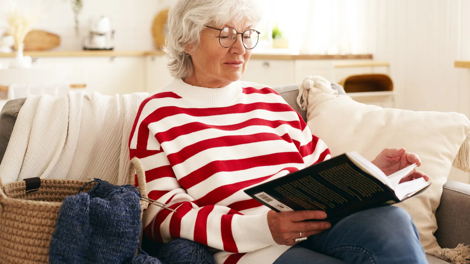 Femme aînée lisant un livre dans un salon lumineux