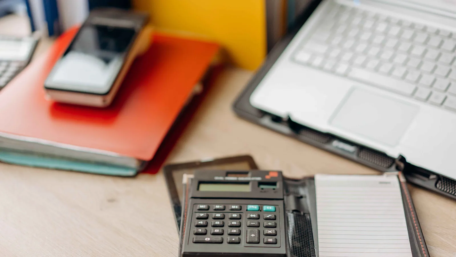 Calculatrice, carnet et ordinateur portable pour examiner les coûts d’une soumission de déménagement