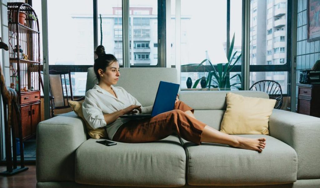 woman-works-from-home-on-a-beige-colored-couch woman-works-from-home-on-a-beige-colored-couch